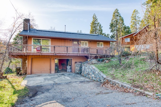 view of front of home featuring a garage and a wooden deck