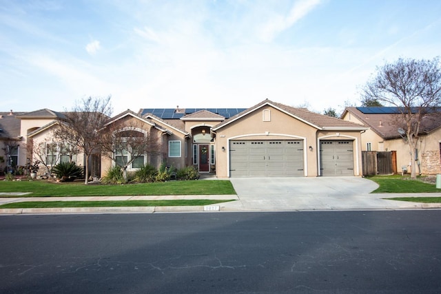 ranch-style house with a front yard, solar panels, and a garage