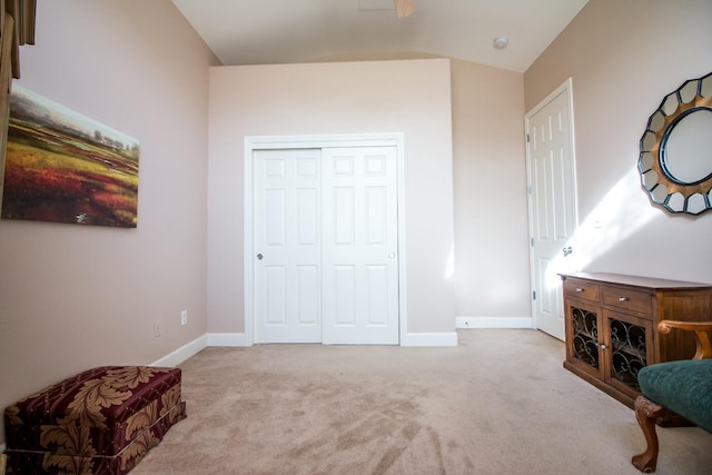 bedroom with a closet, light colored carpet, and vaulted ceiling