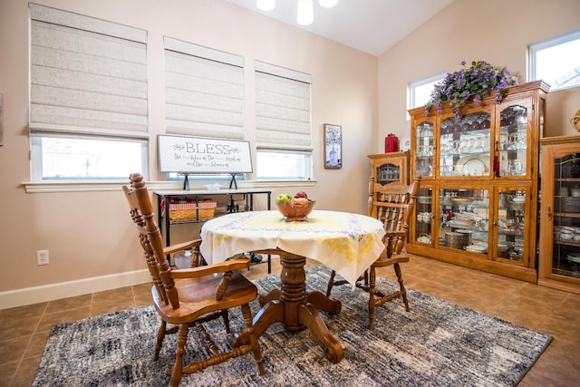 tiled dining space featuring vaulted ceiling