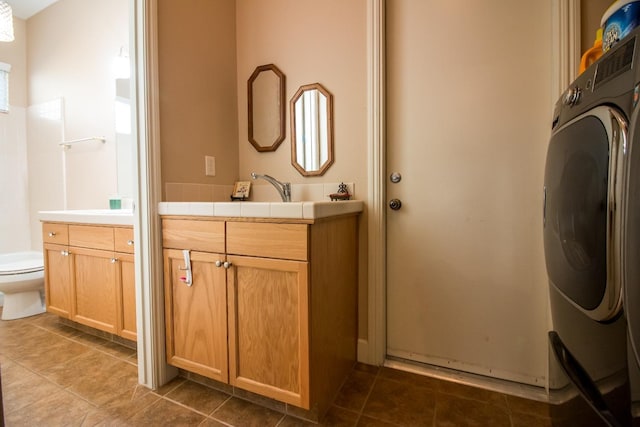 bathroom with washer / dryer, vanity, and toilet