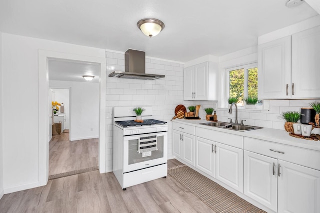 kitchen with white range, sink, wall chimney exhaust hood, light wood-type flooring, and white cabinetry