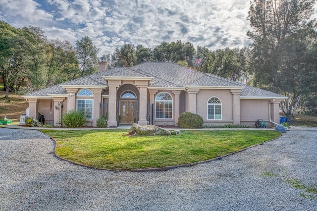 mediterranean / spanish home with a front lawn