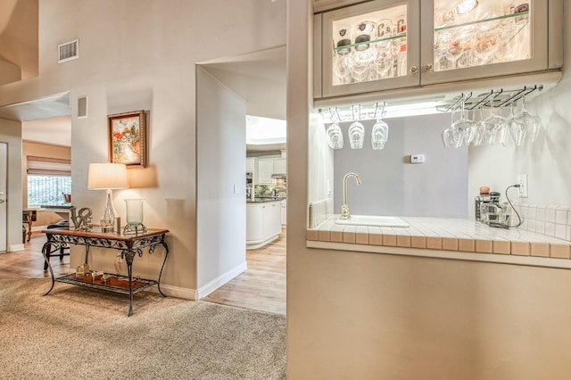 hall featuring light colored carpet and sink