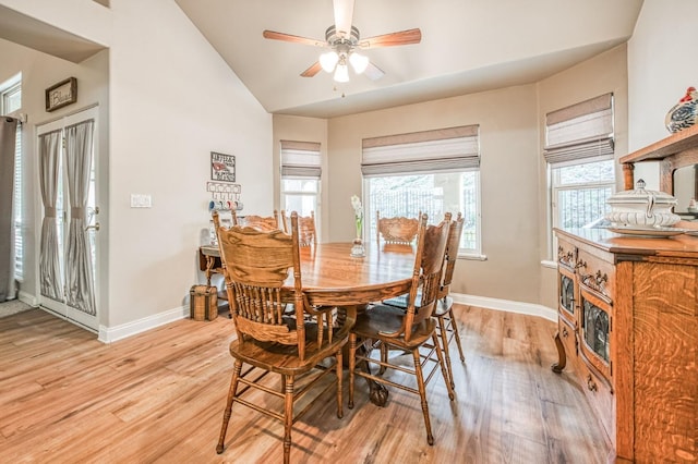 dining room with ceiling fan, light hardwood / wood-style floors, and vaulted ceiling