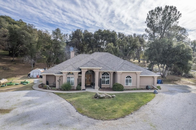 view of front facade with a front lawn and an outdoor structure