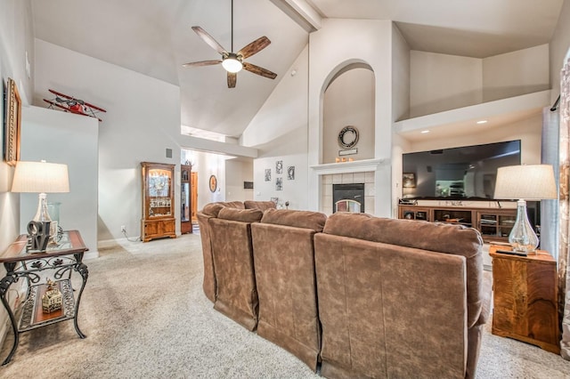 carpeted living room featuring beamed ceiling, ceiling fan, a fireplace, and high vaulted ceiling