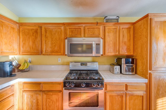 kitchen with tile countertops and stainless steel appliances