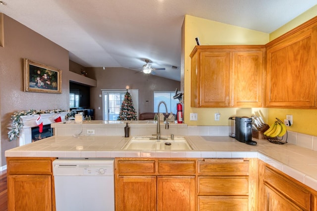 kitchen featuring tile counters, sink, kitchen peninsula, white dishwasher, and vaulted ceiling