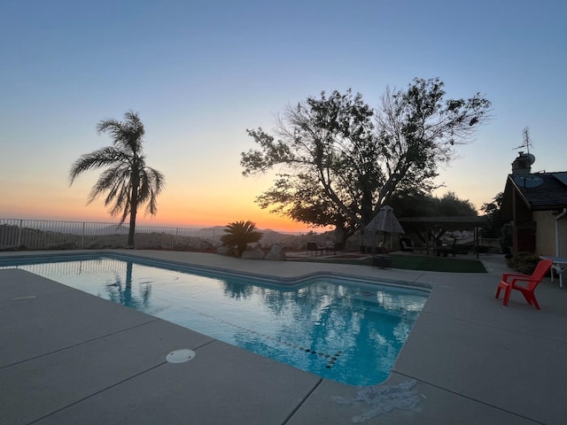 pool at dusk with a patio