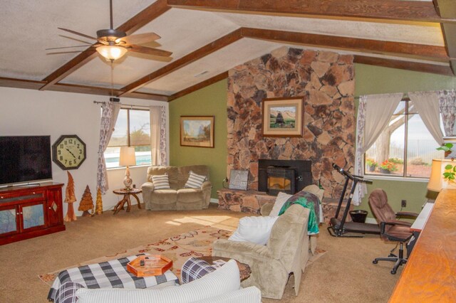 carpeted living room featuring ceiling fan, a fireplace, and vaulted ceiling with beams