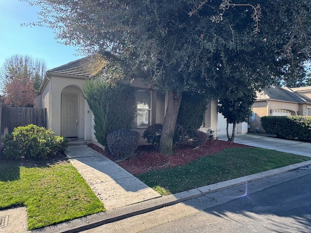 obstructed view of property featuring a garage and a front lawn