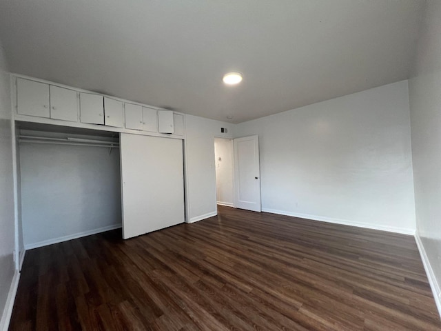 unfurnished bedroom with a closet and dark hardwood / wood-style floors