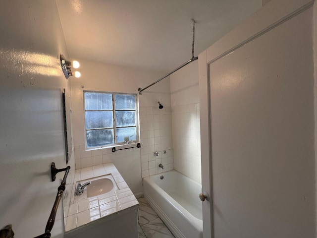 bathroom with tiled shower / bath and vanity