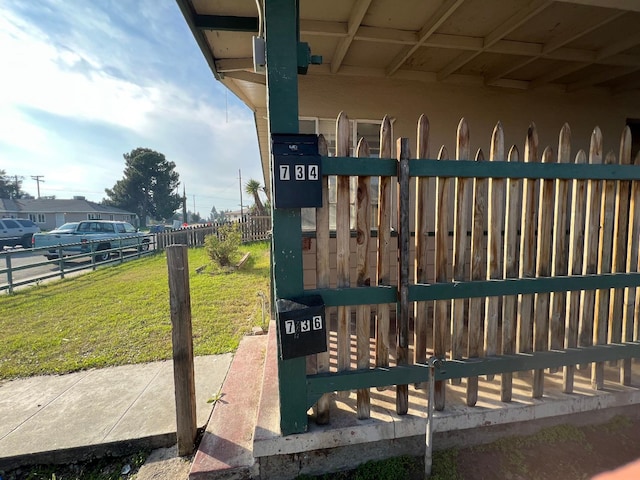 view of gate with a lawn