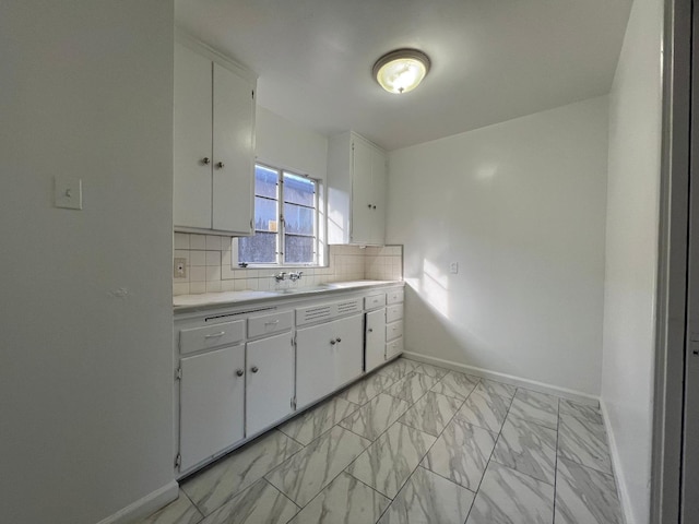 kitchen featuring white cabinetry, sink, and backsplash