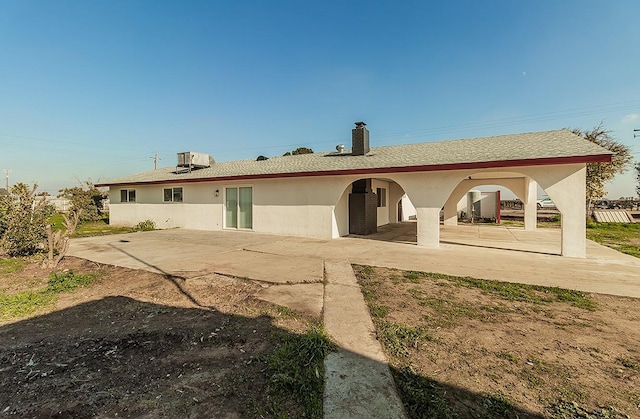 12027 S Brawley Ave, Caruthers, CA 93609 - rear view of house with a chimney, a patio area, and stucco siding