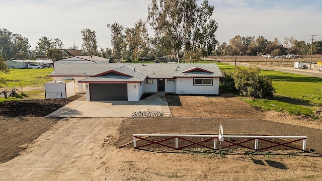 12027 S Brawley Ave, Caruthers, CA 93609 - view of front facade featuring fence, a garage, concrete driveway, and stucco siding