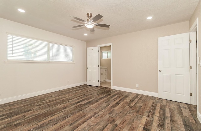 unfurnished bedroom with ceiling fan, dark hardwood / wood-style floors, a textured ceiling, and ensuite bath