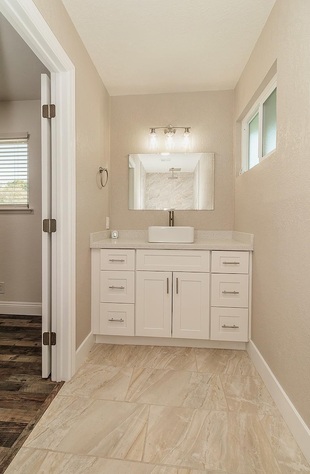 12027 S Brawley Ave, Caruthers, CA 93609 - bathroom with baseboards, vanity, plenty of natural light, and marble look tile flooring