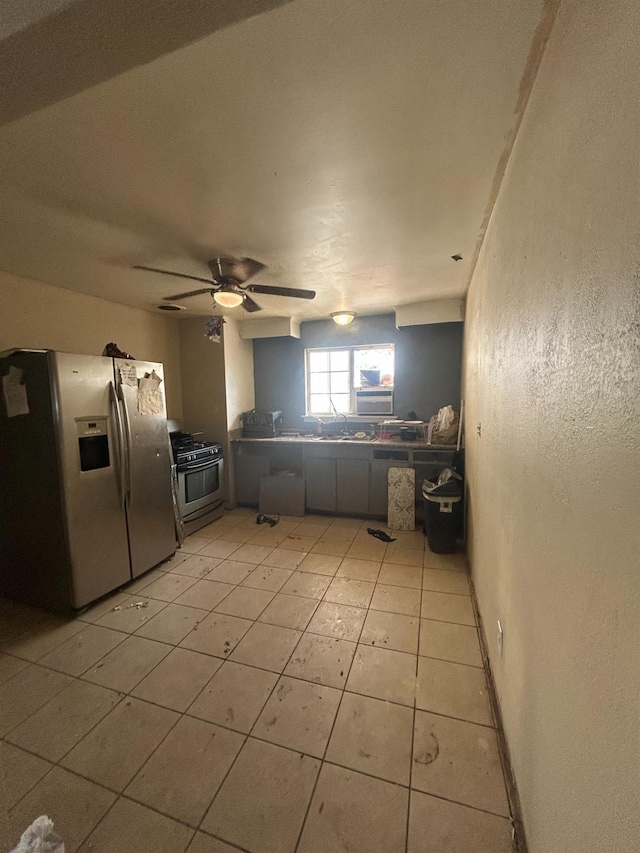 kitchen featuring kitchen peninsula, ceiling fan, light tile patterned floors, and stainless steel appliances