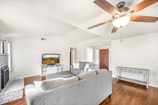 living room featuring a brick fireplace, vaulted ceiling, ceiling fan, and dark wood-type flooring