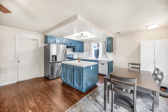 kitchen with blue cabinets, dark wood-type flooring, a textured ceiling, and appliances with stainless steel finishes