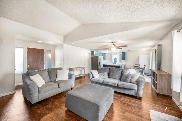 living room featuring a textured ceiling, ceiling fan, dark wood-type flooring, and vaulted ceiling