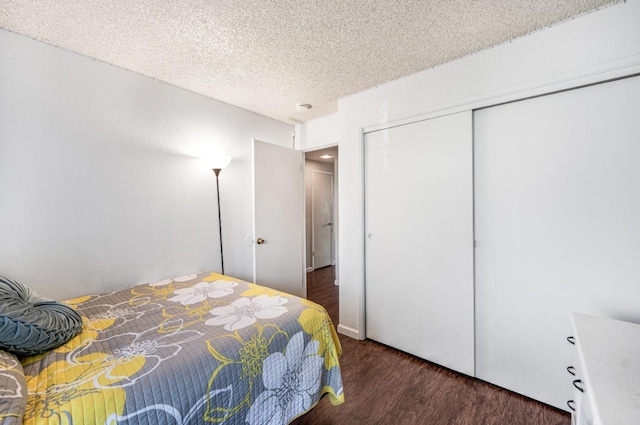 bedroom featuring a textured ceiling, dark hardwood / wood-style floors, and a closet