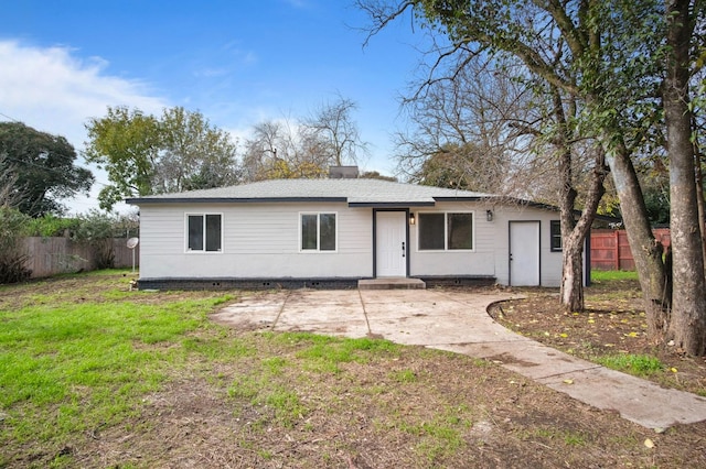 ranch-style house featuring a front yard, fence, and a patio