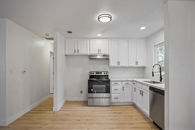 kitchen with under cabinet range hood, stainless steel appliances, a sink, visible vents, and tasteful backsplash