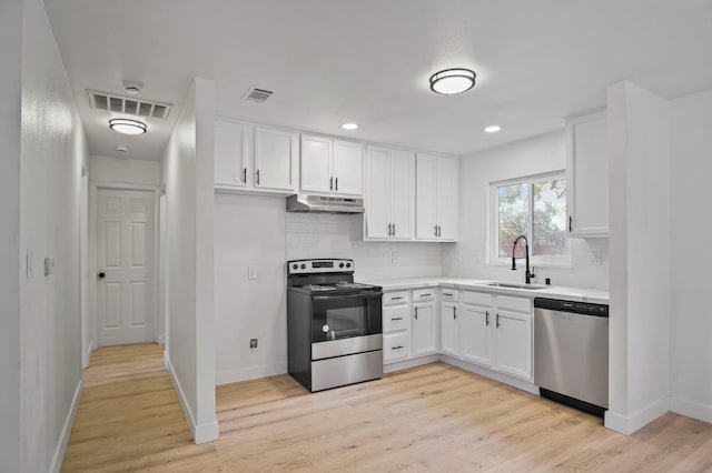 kitchen with decorative backsplash, stainless steel appliances, sink, light hardwood / wood-style flooring, and white cabinetry