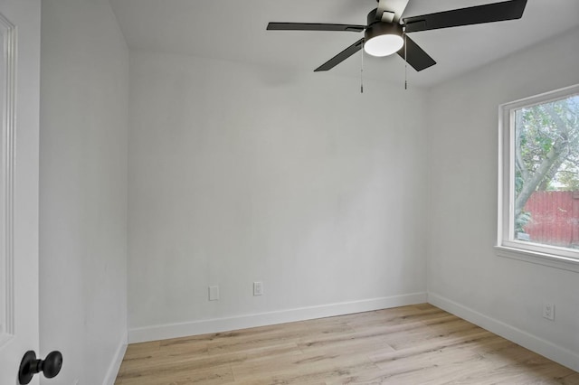 spare room with light wood-style floors, ceiling fan, and baseboards