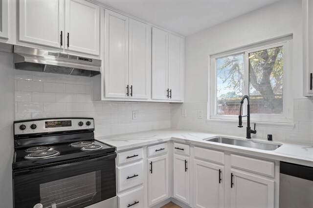 kitchen with light stone countertops, white cabinetry, sink, stainless steel appliances, and decorative backsplash