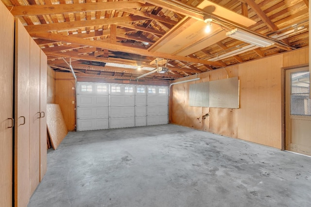 garage featuring wood walls and a garage door opener