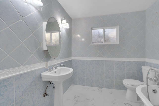 bathroom with toilet, tile walls, and a tub