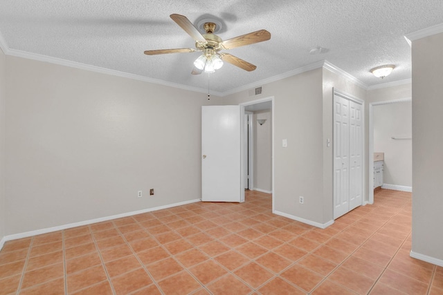 tiled empty room with ceiling fan, ornamental molding, and a textured ceiling