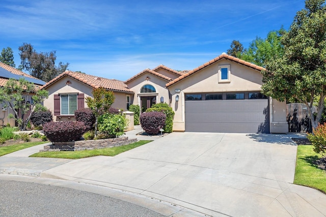 10810 N Matus Ave, Fresno, CA 93730 - mediterranean / spanish-style home with an attached garage, stucco siding, a tiled roof, and concrete driveway