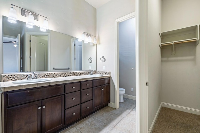 10810 N Matus Ave, Fresno, CA 93730 - full bathroom featuring a sink, baseboards, toilet, and double vanity