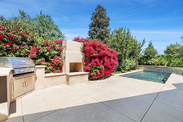 10810 N Matus Ave, Fresno, CA 93730 - pool with a patio area, exterior fireplace, and an outdoor kitchen