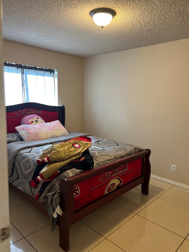 bedroom featuring light tile patterned flooring and a textured ceiling