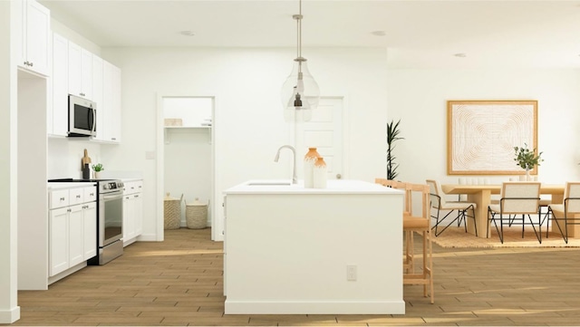 kitchen with pendant lighting, white cabinetry, stainless steel appliances, sink, and light wood-type flooring