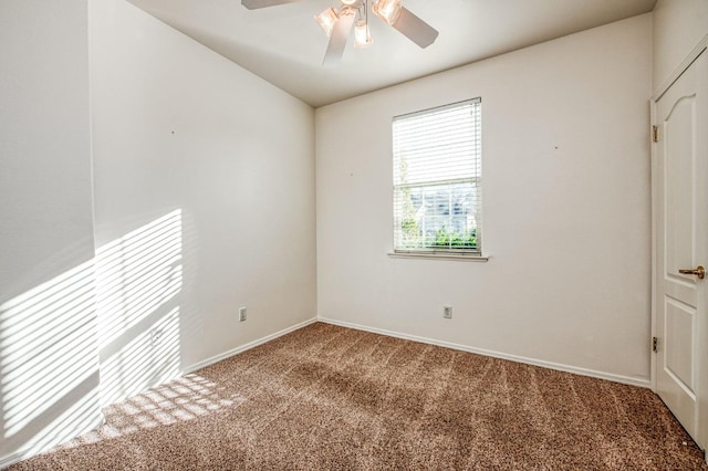 empty room featuring ceiling fan and carpet