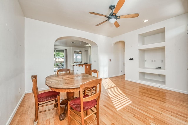 dining room featuring ceiling fan, hardwood / wood-style flooring, and built in features