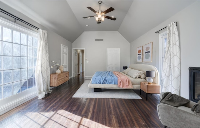 bedroom featuring lofted ceiling, multiple windows, ceiling fan, and dark hardwood / wood-style floors