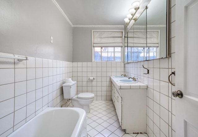 bathroom featuring tile patterned flooring, a tub to relax in, toilet, tile walls, and ornamental molding