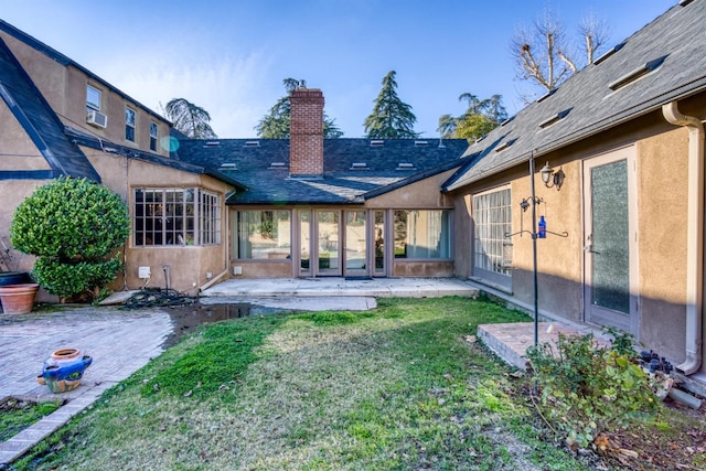 back of property with a lawn, a patio area, and cooling unit