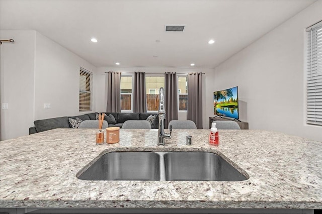 kitchen with light stone countertops and sink