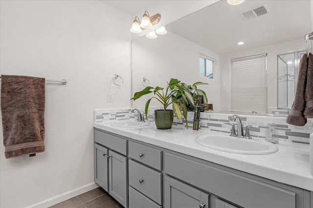 bathroom with tile patterned floors, vanity, and tasteful backsplash