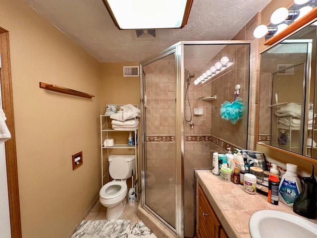 bathroom featuring tile patterned floors, toilet, a shower with shower door, a textured ceiling, and vanity